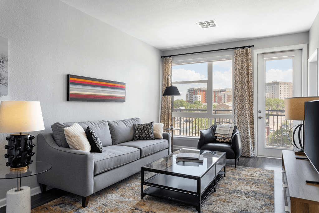a living room with a gray couch and a glass coffee table
