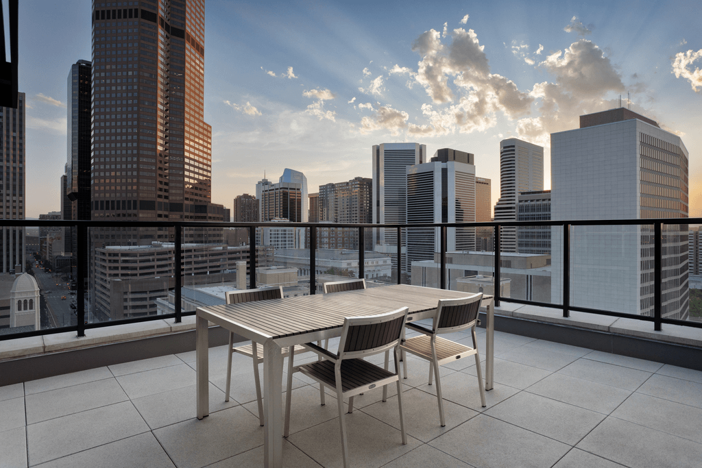 a table and chairs on a balcony overlooking the city