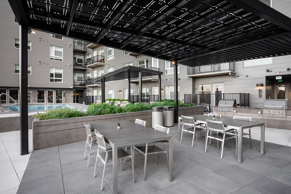 an outdoor patio area with tables and chairs and a pool