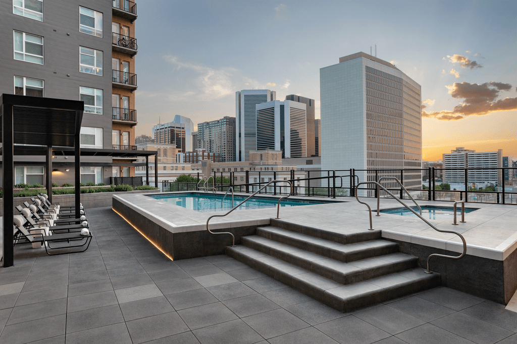 apartments with a pool and city skyline in the background