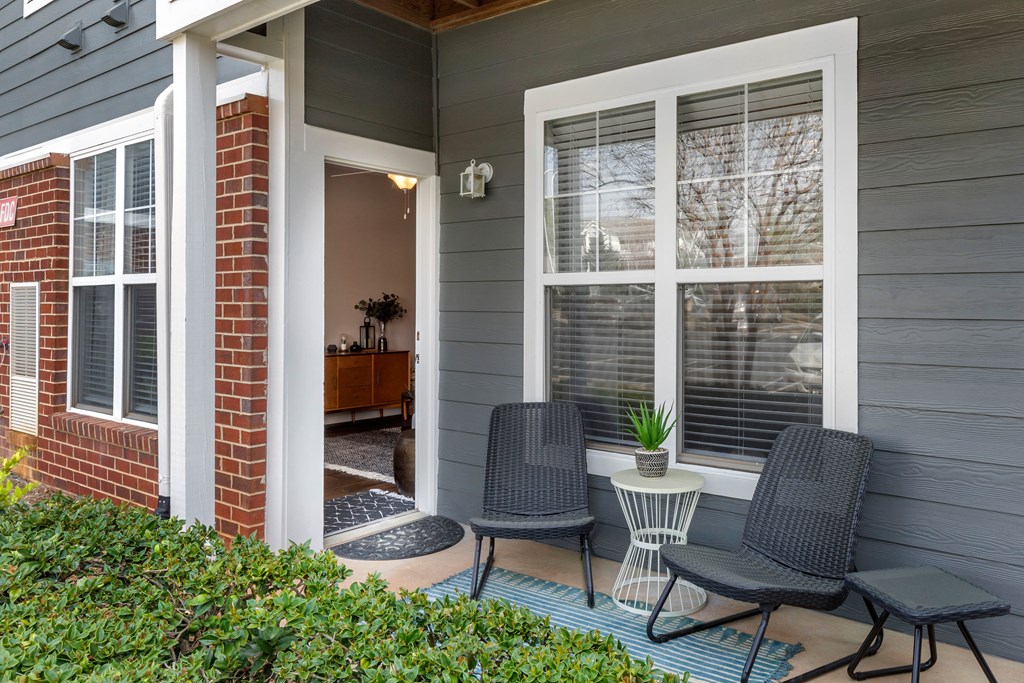 a front porch with two chairs and a small table