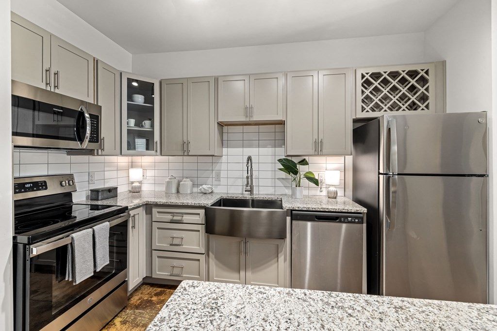 a kitchen with white cabinets and granite countertops