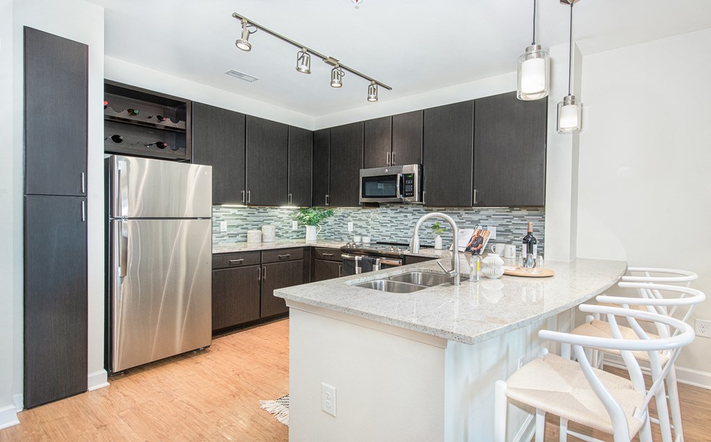 a kitchen with dark cabinets and a large island