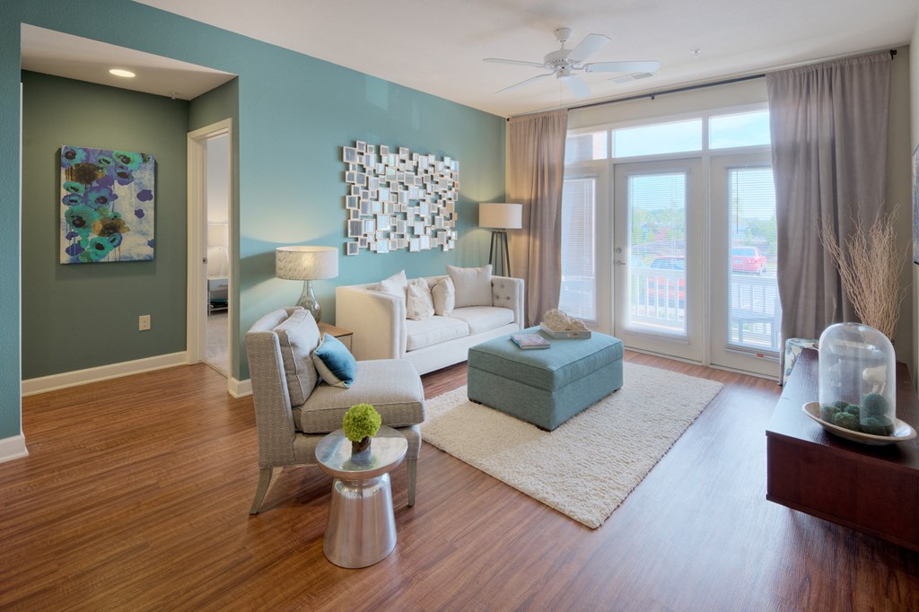 a living room with a white couch and a blue ottoman