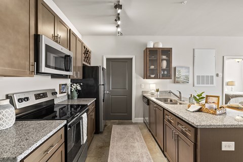 A kitchen with brown cabinets and a black refrigerator.