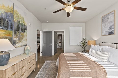 A bedroom with a large bed and a ceiling fan.