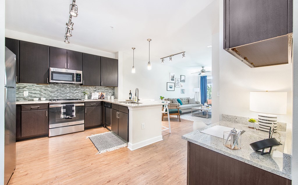 a kitchen with dark wood cabinets and stainless steel appliances