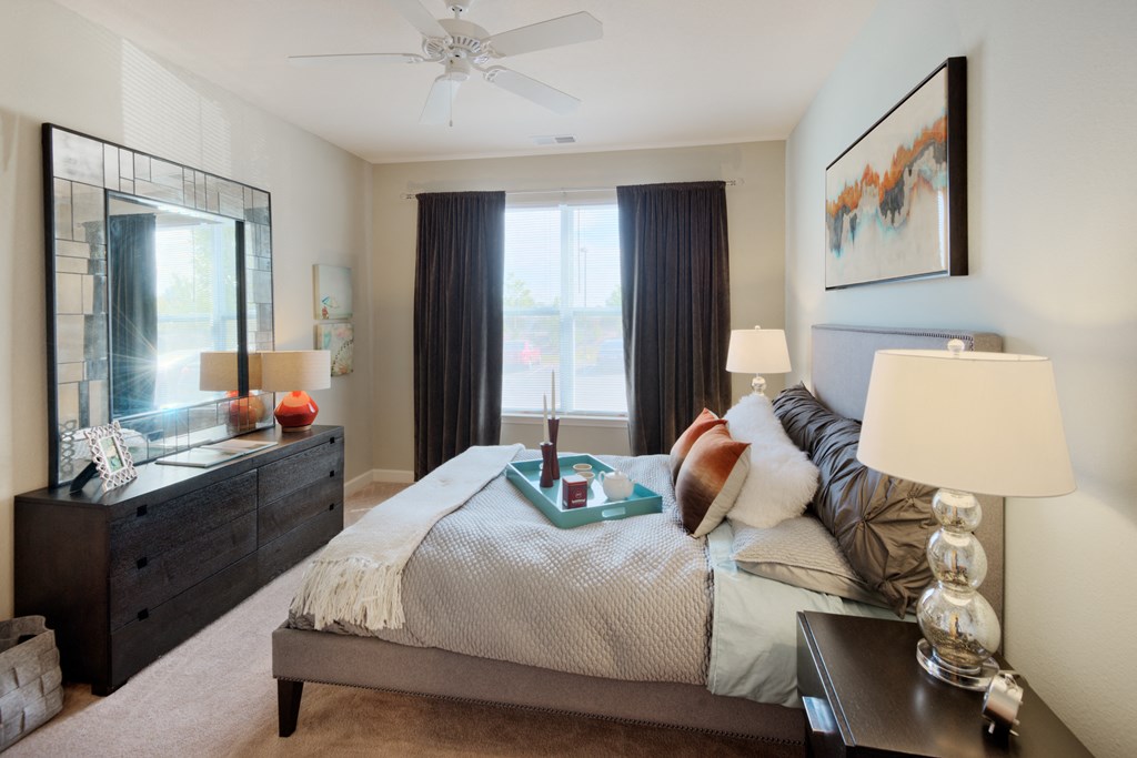 a bedroom with a bed and a dresser with a mirror