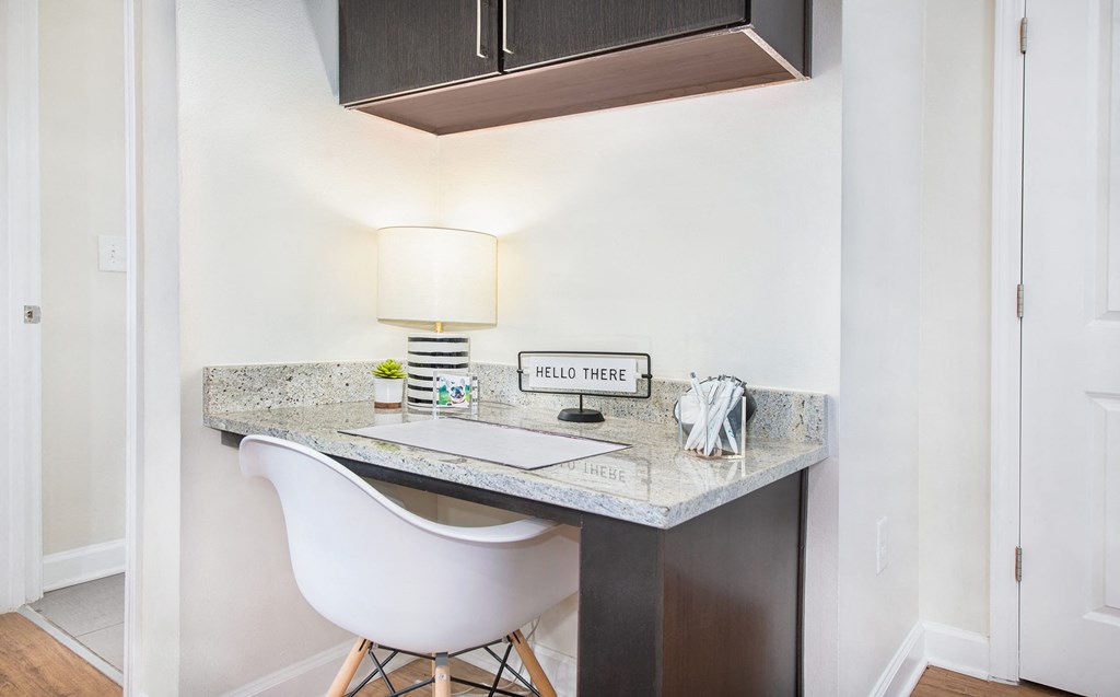 a desk with a chair and lamp at the enclave at woodbridge apartments in sugar land,