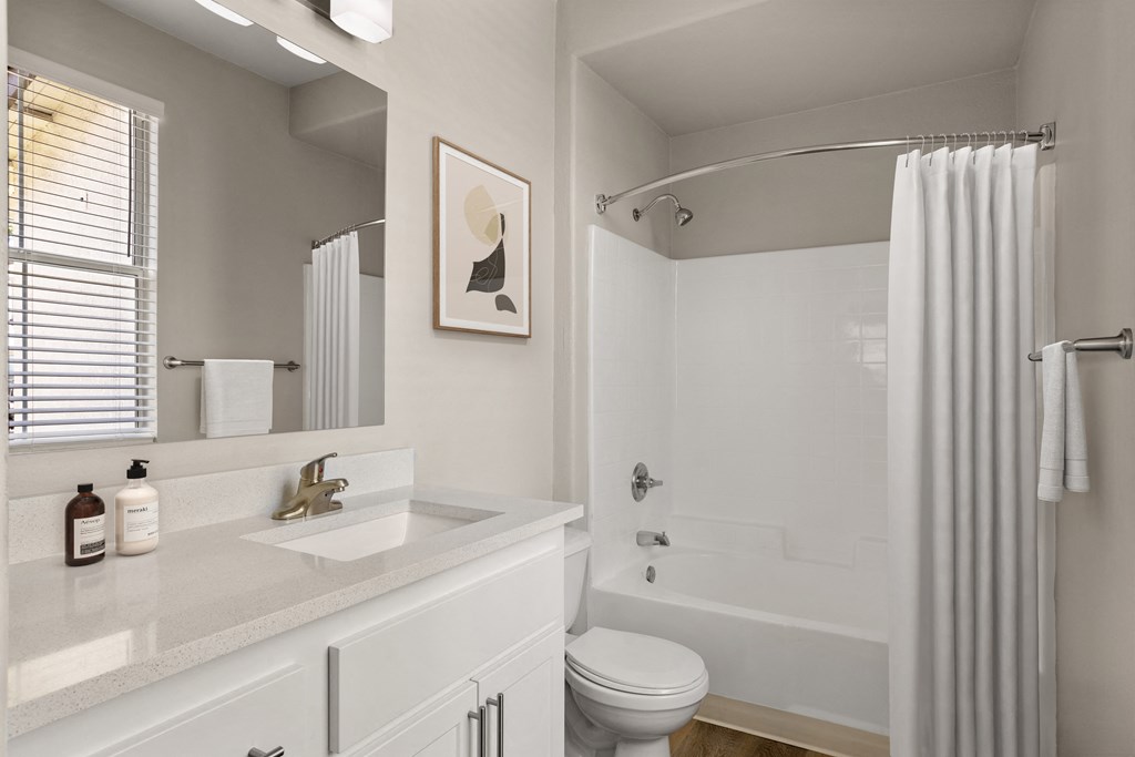 a bathroom with a white sink and toilet next to a white bathtub with a shower curtain