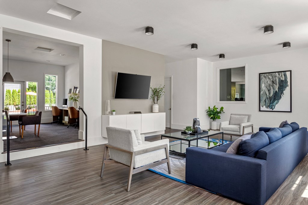 a living room with a blue couch and chairs and a television