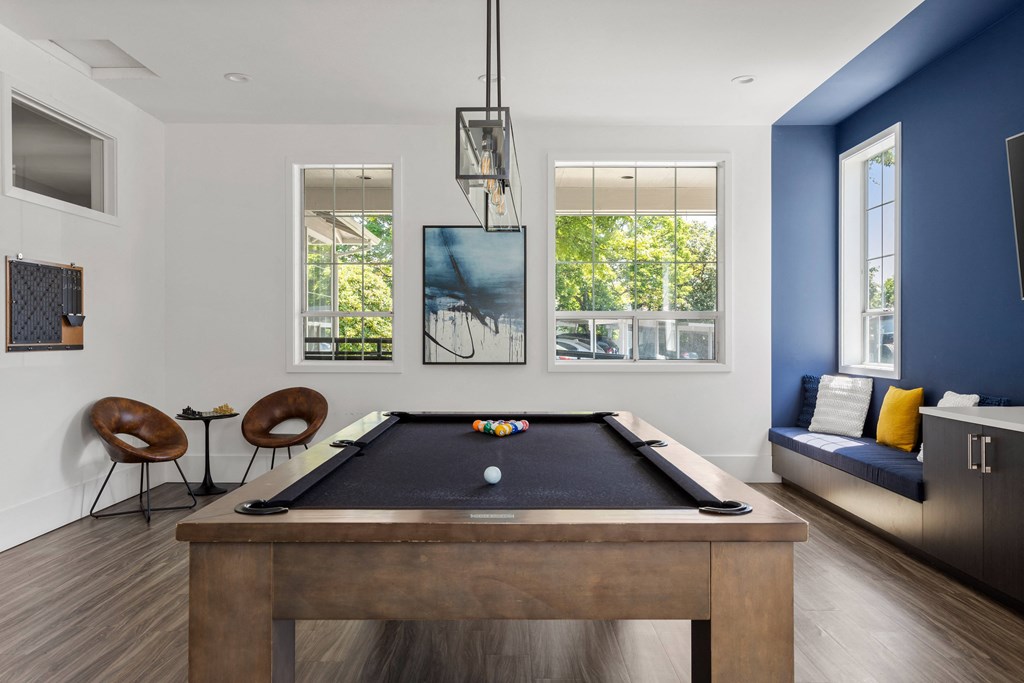 a living room with a pool table and a blue accent wall