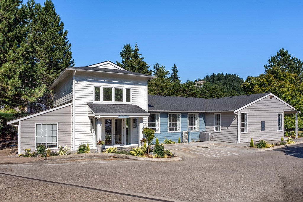 a white house with a parking lot and a driveway
