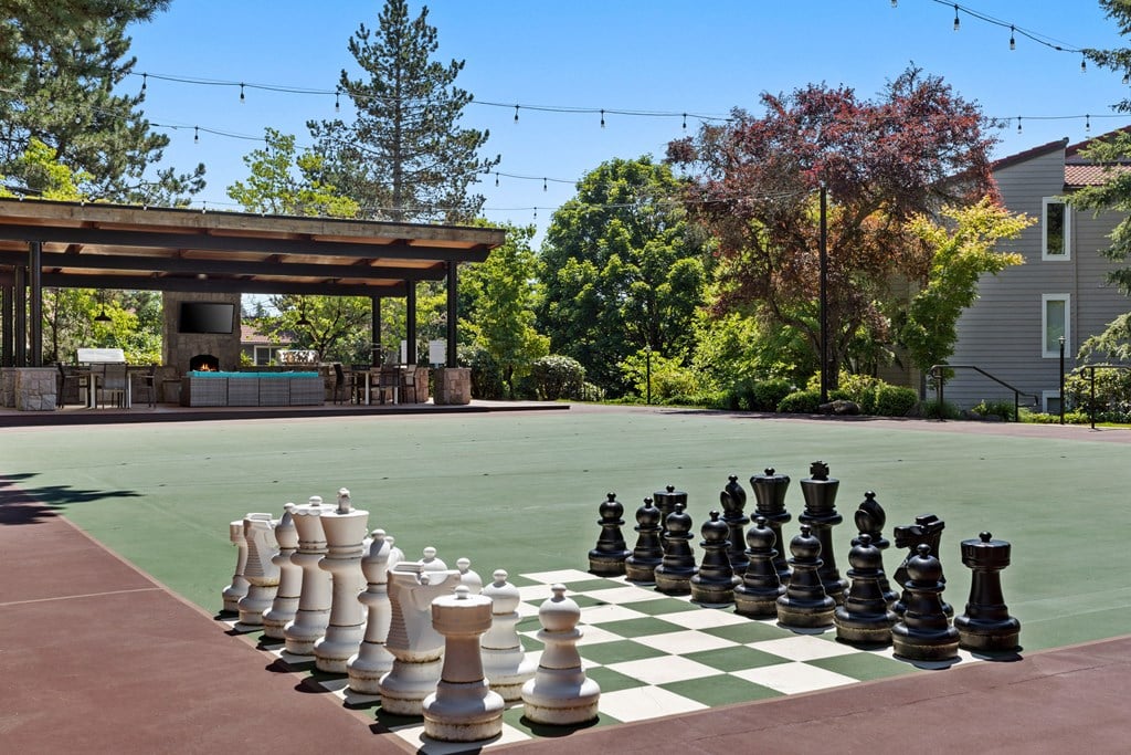 a large chess set on a court in front of a house