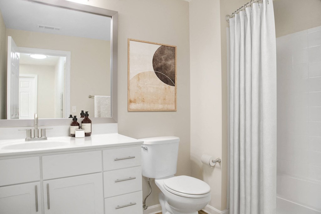 a bathroom with a white shower curtain and a white toilet next to a white sink
