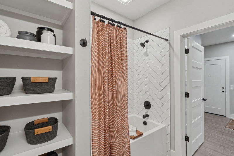 a bathroom with a shower and shelves and a door