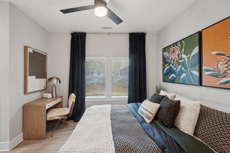 a bedroom with a bed and a ceiling fan