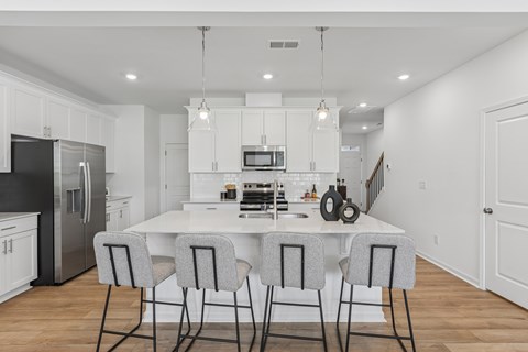 modern kitchen with a white table and grey chairs.