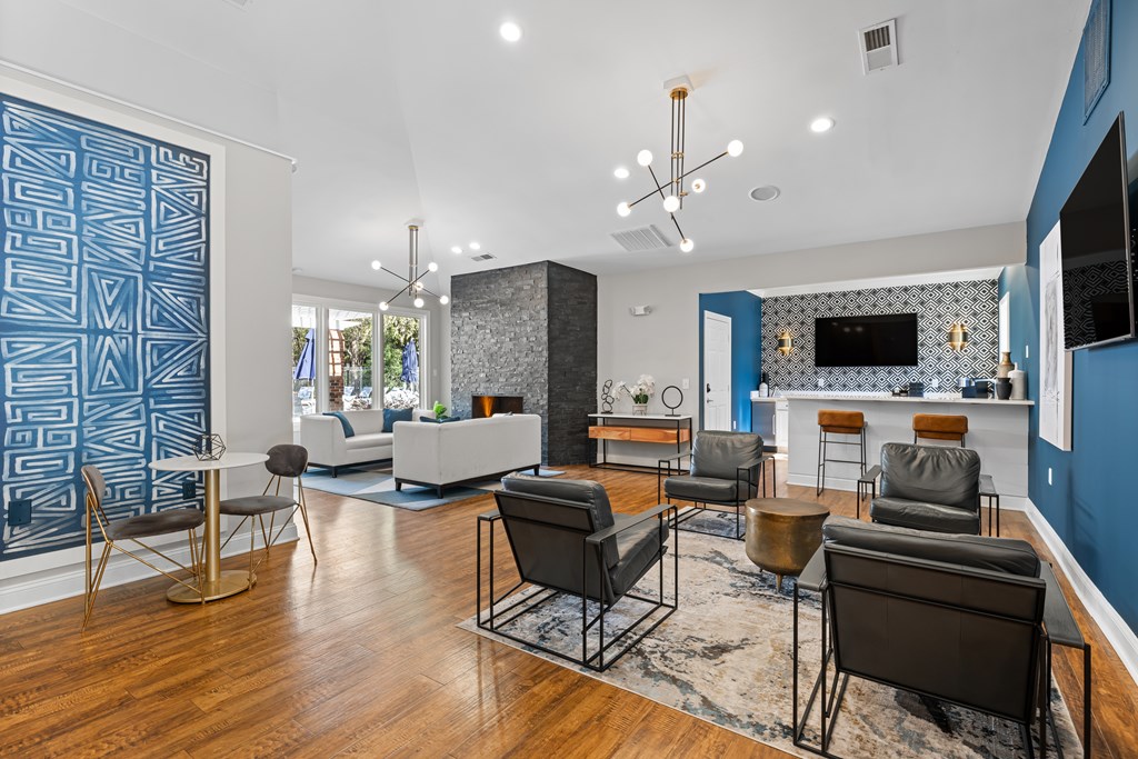 A living room with a blue accent wall and a patterned blue wallpaper.