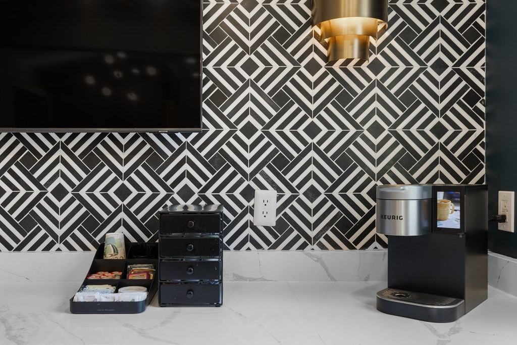 A black and white tiled wall with a pattern and a black box with a white label on it.