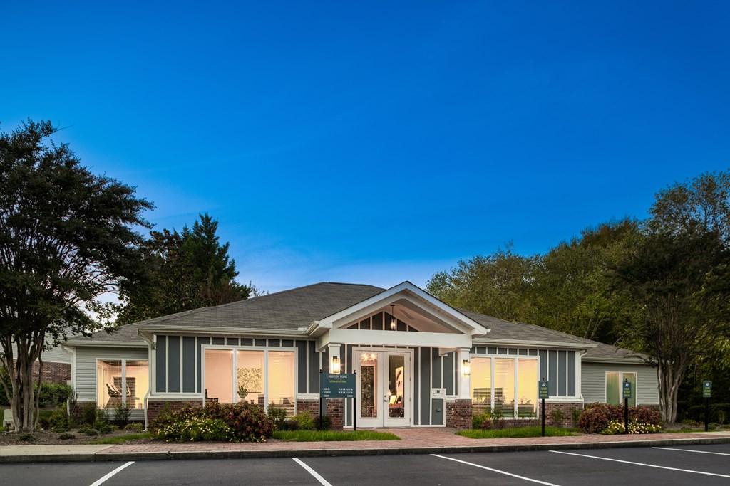 A house with a grey roof and a parking lot in front.