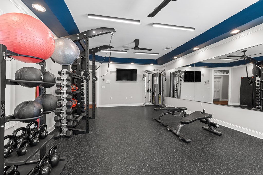 A gym with a variety of equipment including weights and a bench press.