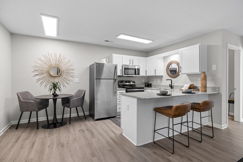 A kitchen with a table and chairs.