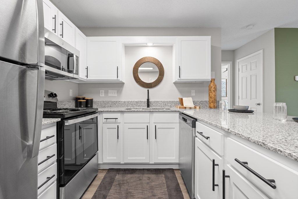 A modern kitchen with white cabinets and a stainless steel refrigerator.