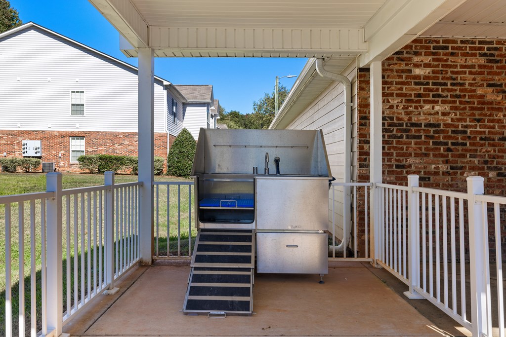 A stainless steel refrigerator is on a patio.