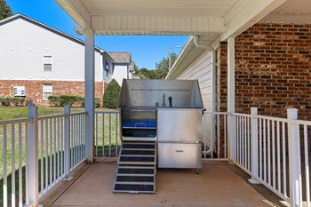 A stainless steel refrigerator is on a patio.
