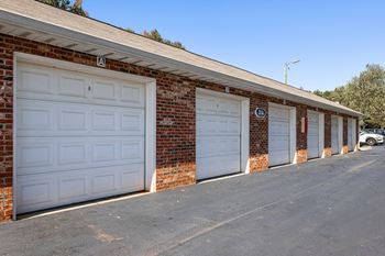 A row of garage doors on a brick building.