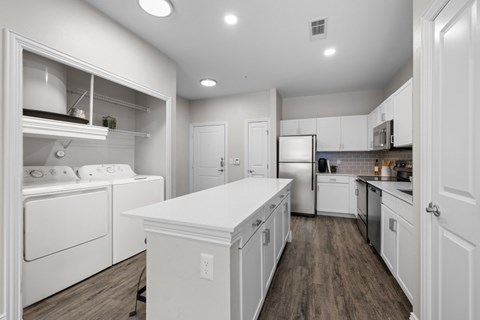 A modern kitchen with white appliances and cabinets.