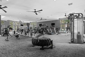 A gym with a variety of equipment including treadmills, weights, and exercise machines.