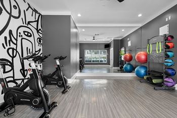A room with exercise equipment and a wall with drawings.