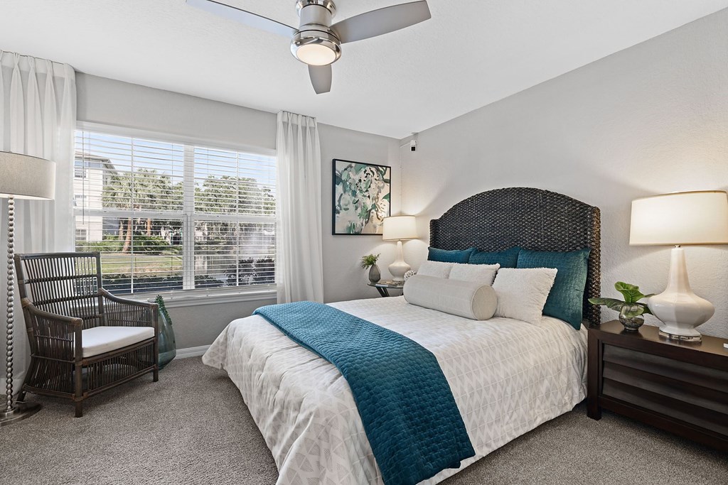 A bedroom with a large bed and a ceiling fan.