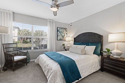 A bedroom with a large bed and a ceiling fan.