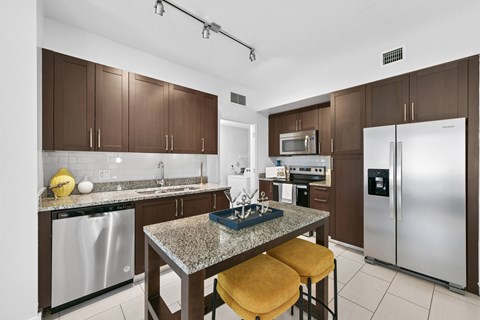 A kitchen with brown cabinets and a granite countertop.