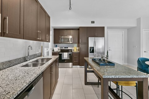 A kitchen with brown cabinets and granite countertops.
