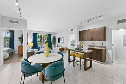 A modern dining room with a round table and blue chairs.
