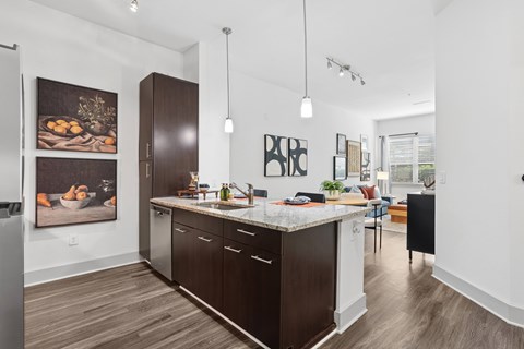 A kitchen with dark wood floors and white walls.