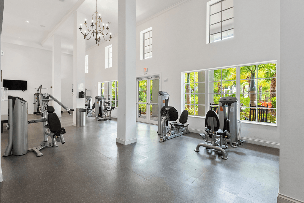 A spacious gym with a variety of equipment and a balcony with a view.
