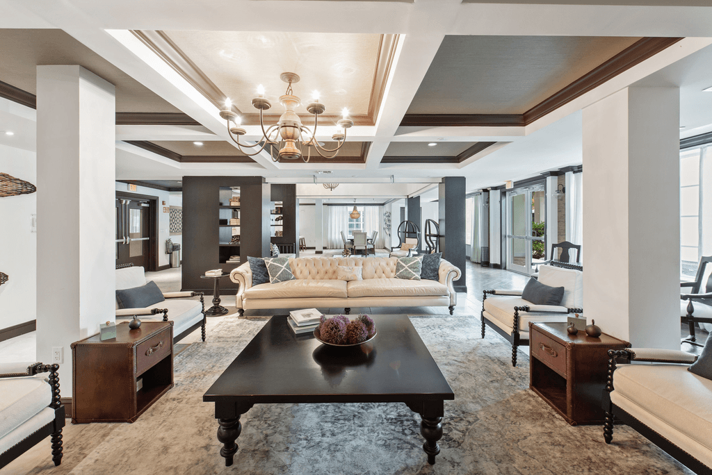 A large, elegant living room with a chandelier, sofas, and a coffee table.