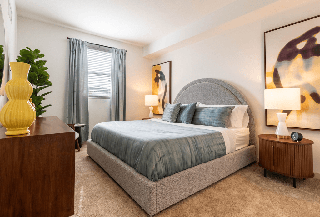 A bedroom with a bed, nightstand, and lamp.