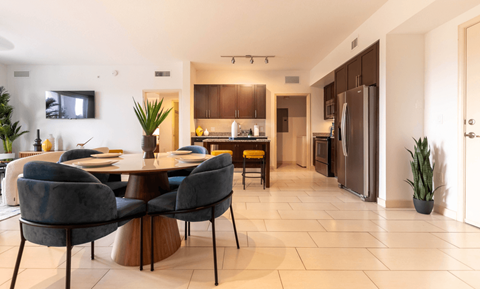 A modern kitchen with a dining table and chairs.