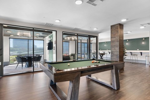 A pool table in a room with a view of the city.