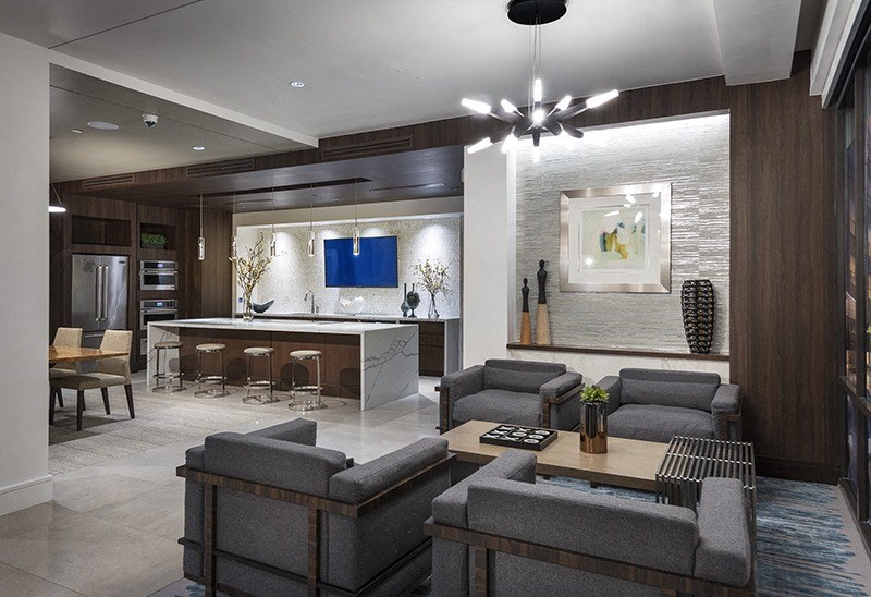 A modern living room with a grey sofa set and a bar area.