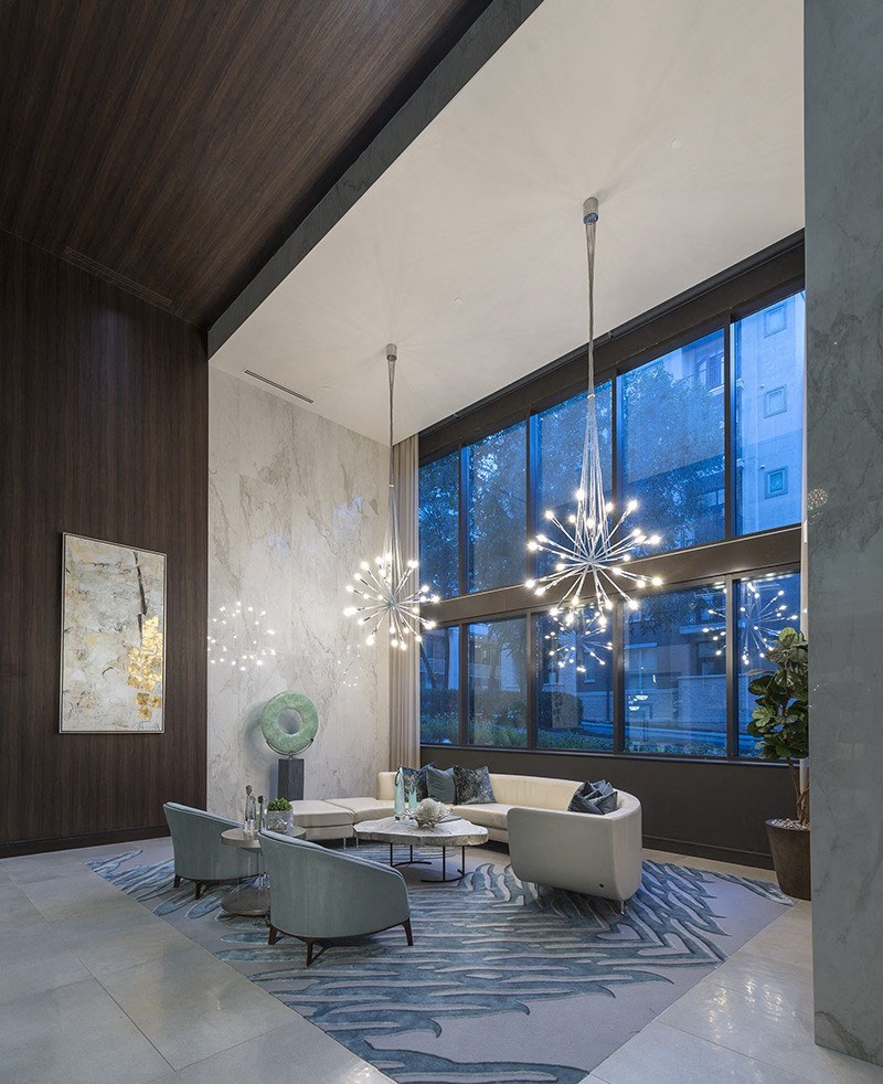 A modern living room with a large chandelier and a view of the city.