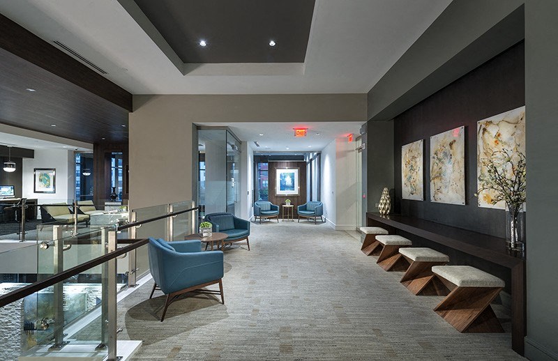 A hallway with a bench and a chair on the right side.