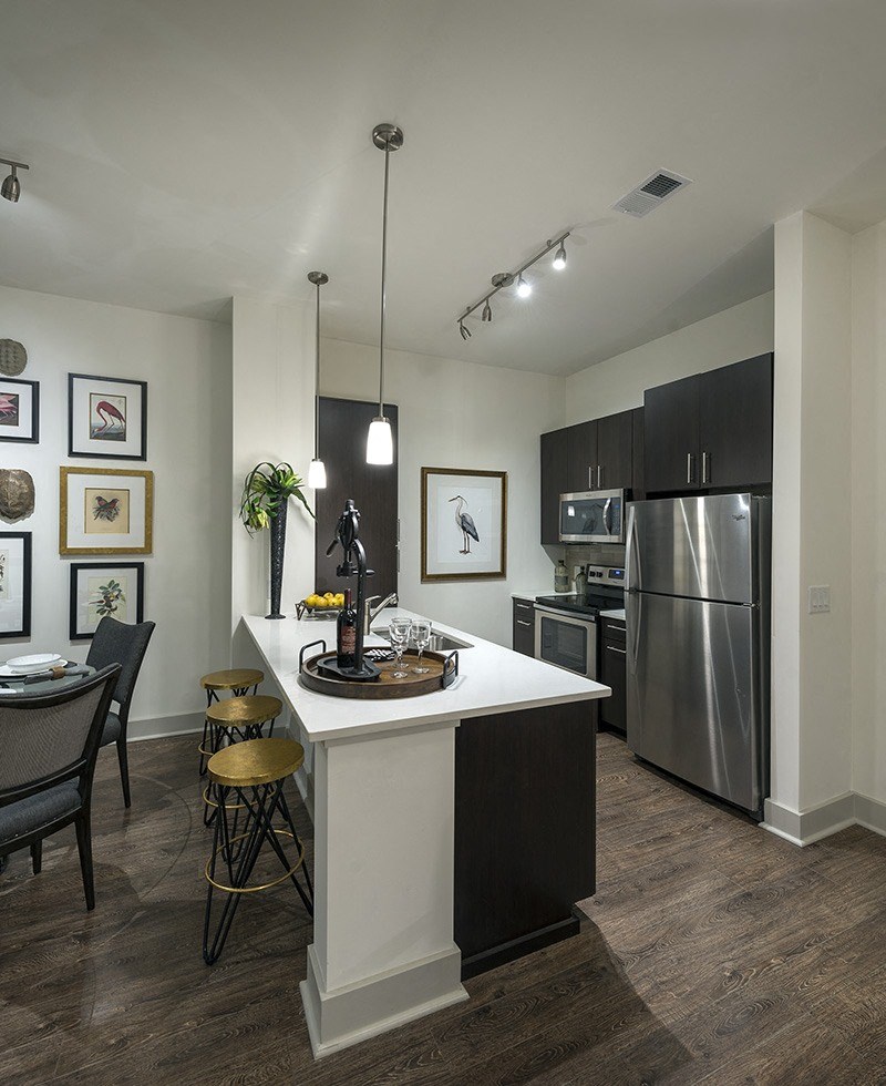 A modern kitchen with a white island and stainless steel appliances.