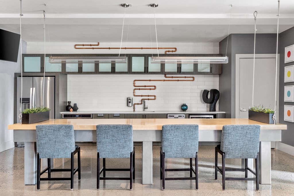 a kitchen with a large island and four blue chairs